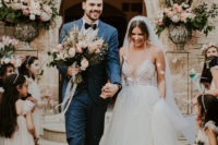 03 The groom was wearing a blue suit with a black bow tie, and the bride was wearing a wedding gown with a lace bodice and a deep plunging neckline