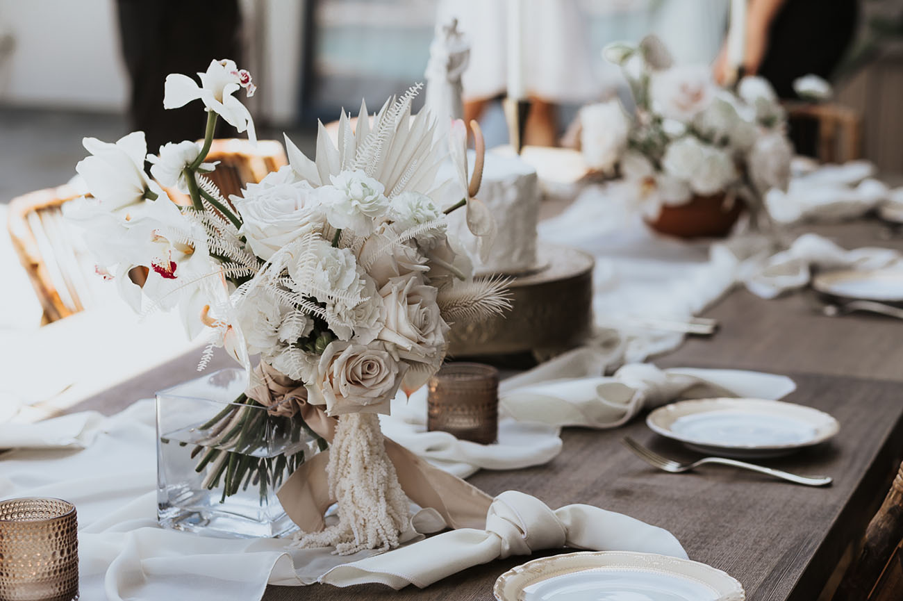 The decor was simple and white, with the wedding bouquet of white fronds and pale blooms
