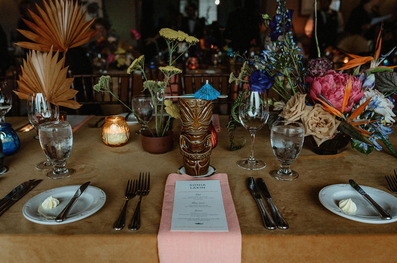 The tables were decorated in a whimsy way, with bright blooms, candles, colored fronds and bright napkins