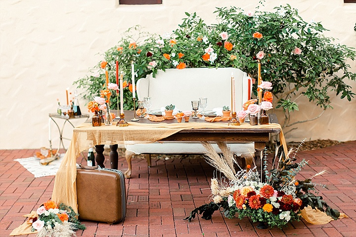 The wedding table was done with greenery and bold blooms, sandy table runner, bright candles and succulents