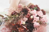 a bold wedding bouquet with smoke bush, burgundy ranunculus and other blooms in burgundy and pink