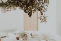 a decadent fall wedding overhead installation with white blooms, smoke bush and dried leaves for a fall wedding