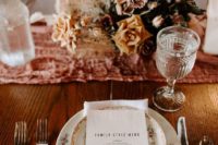 a refined wedding centerpiece with pink and rust blooms, dark leaves and smoke bush for a fall wedding
