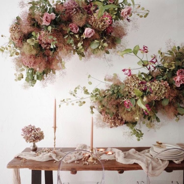 exuberant arrangements with smoke bush, greenery and pink roses make the space very chic and very refined