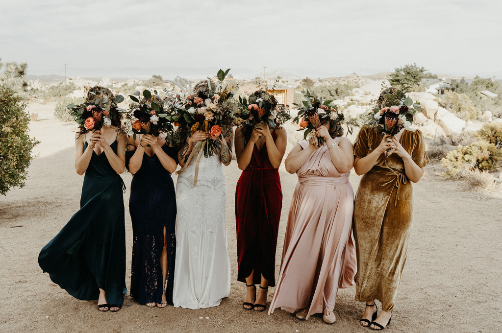 The bridesmaids were wearing mismatching maxi dresses in bold colors and minimalist shoes