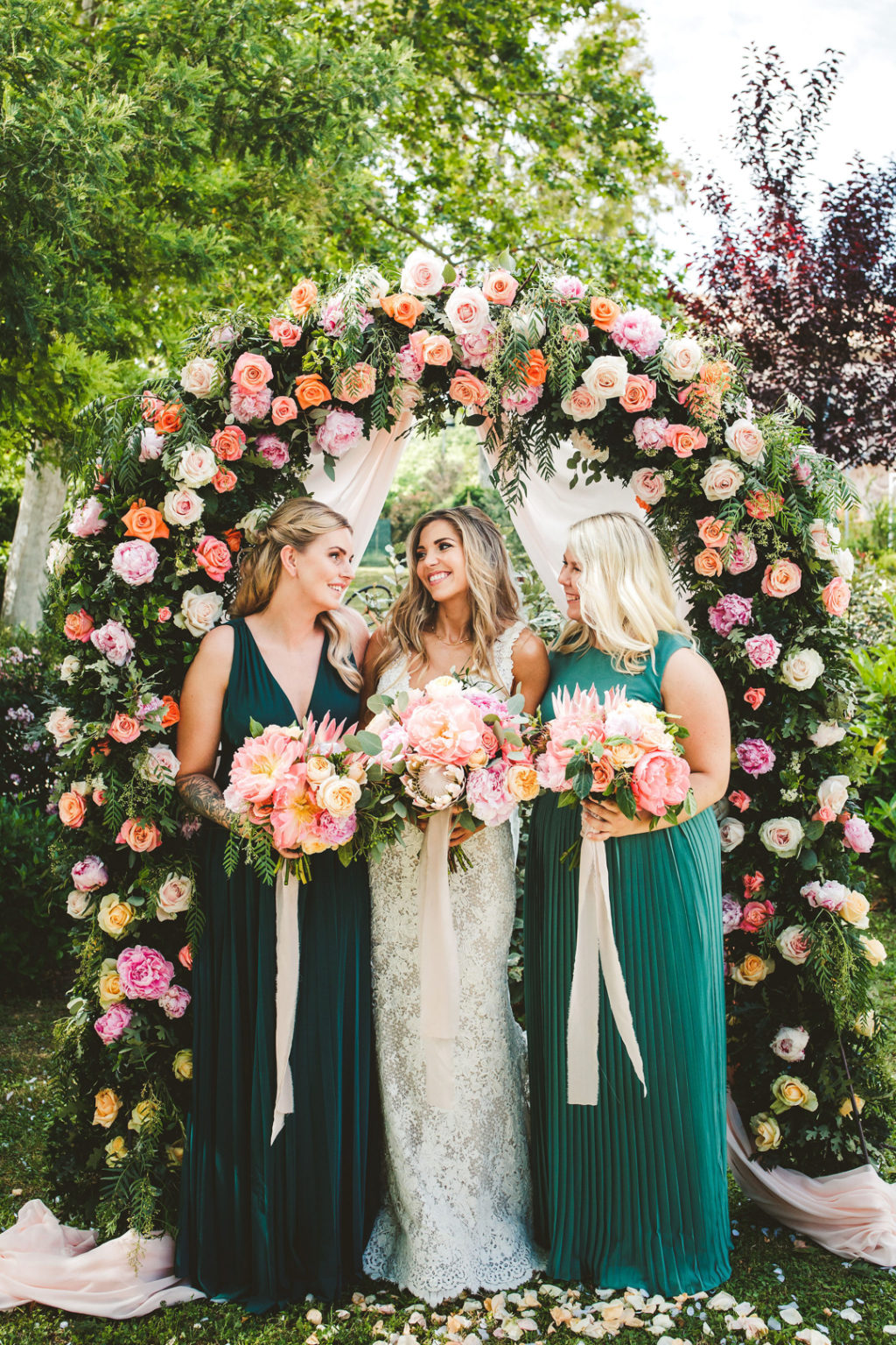 The wedding arch was decorated with greenery and bold and blush blooms all over