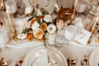 08 The wedding tablescape was done with peachy and gilded blooms, candles, copper cutlery and and other touches