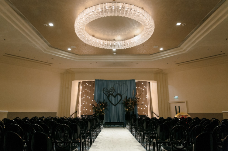 The wedding ceremony space was done with black chairs and vases with pampas grass, greenery and blush blooms