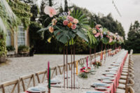 10 The wedding tablescape was done with pink mats, lush tropical florals and leaves, blue menus and colorful candles