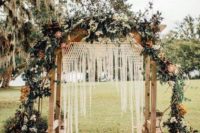 14 a boho backyard wedding arch with macrame, greenery, bright and white blooms and a boho rug