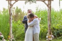 16 a rustic vintage wedding arch made of birchwood, with greenery and pink blooms, family photos