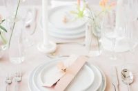 a delicate minimal cluster wedding centerpiece of glasses and peachy blooms is a cool idea for a spring wedding
