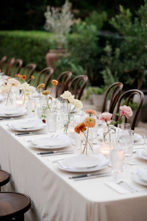 clear glasses with neutral and colorful blooms are classic centerpieces that match any wedding theme and style