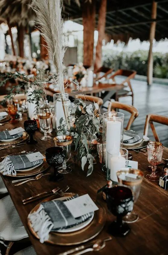 simple boho fall table decor with pampas grass, greenery and some white blooms and candles is a very chic and easy to recreate idea