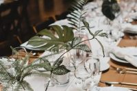 simple clear glasses and vases with statement foliage and greenery make the table look fresh and stylish