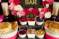 0 2a bold and glam waffle bar with bright pink and white blooms, pink and polka dot stands, waffles, fruits, sauces and dips
