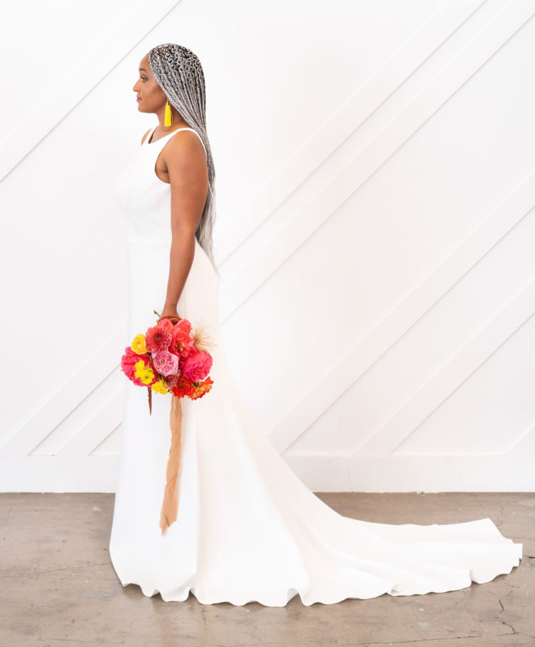 The bride was wearing a sheath plain wedding dress with a train and yellow tassel earrings