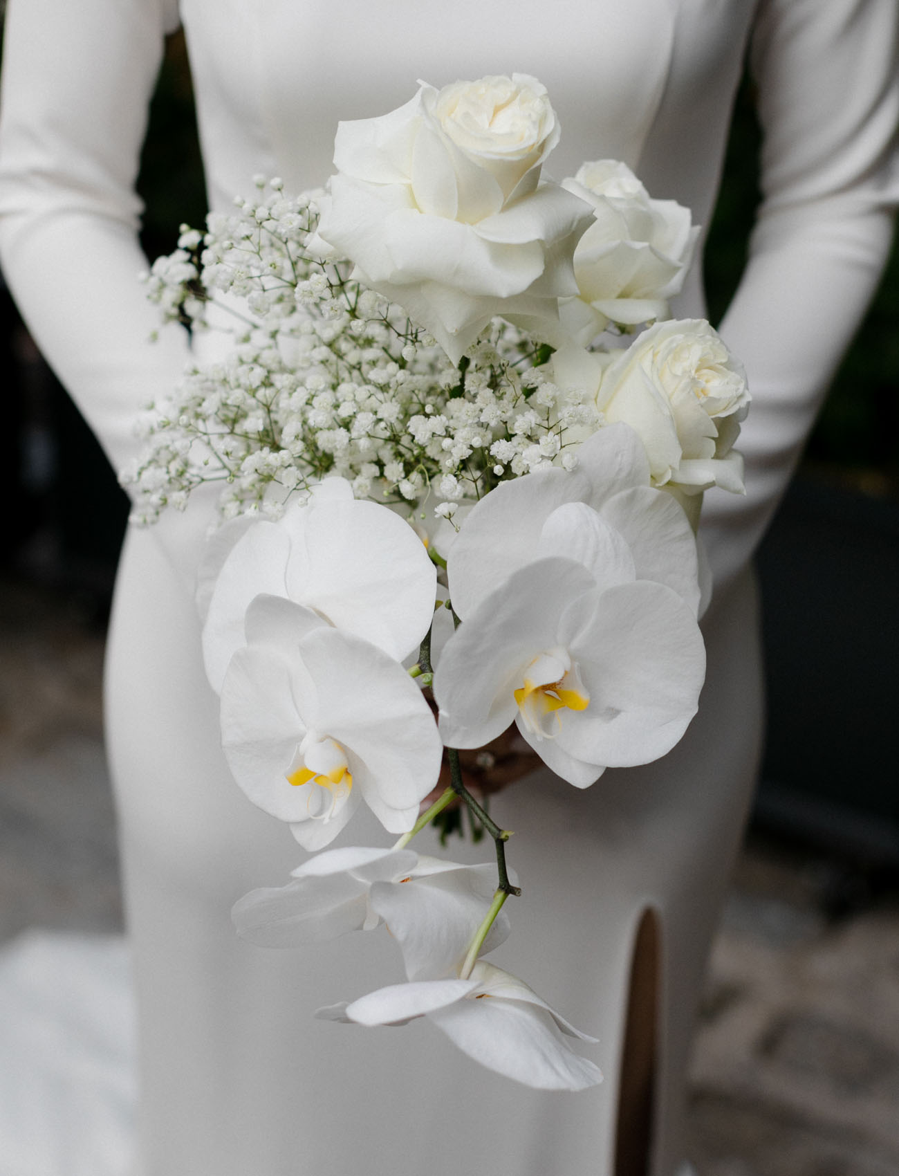 The wedding bouquet was done with white roses, orchids and baby's breath
