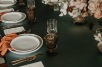 07 The wedding tablescape was done with a blue tablecloth, rust-colored napkins, chic glasses and refined florals