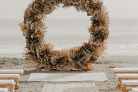 a round wedding arch made of dried leaves