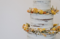 08 The wedding cake was a naked one decorated with dried blooms and greenery