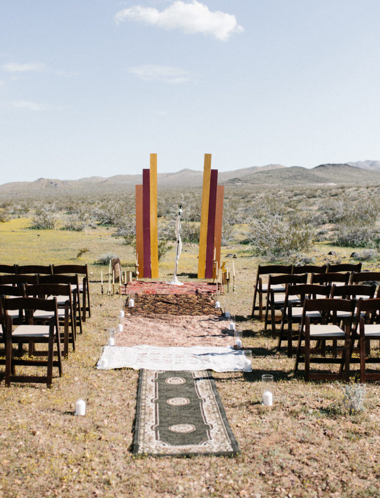 The wedding ceremony space was done with layered rugs, candles and colorful decor plus candlesticks