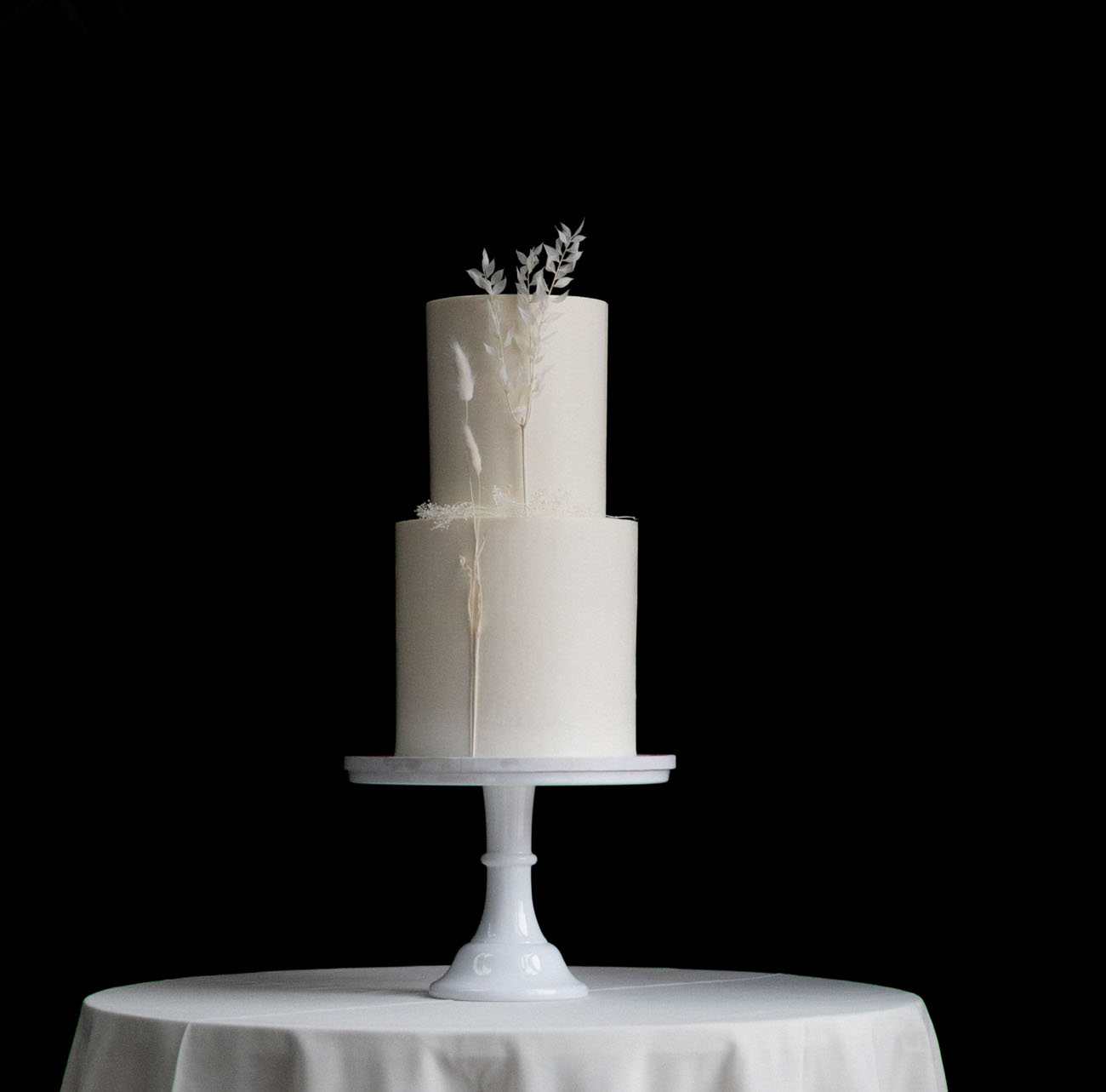 The wedding cake was a pure white one, with some white dried blooms on it