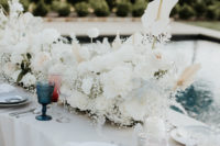 09 The wedding table was curved, with lush white blooms and blue glasses