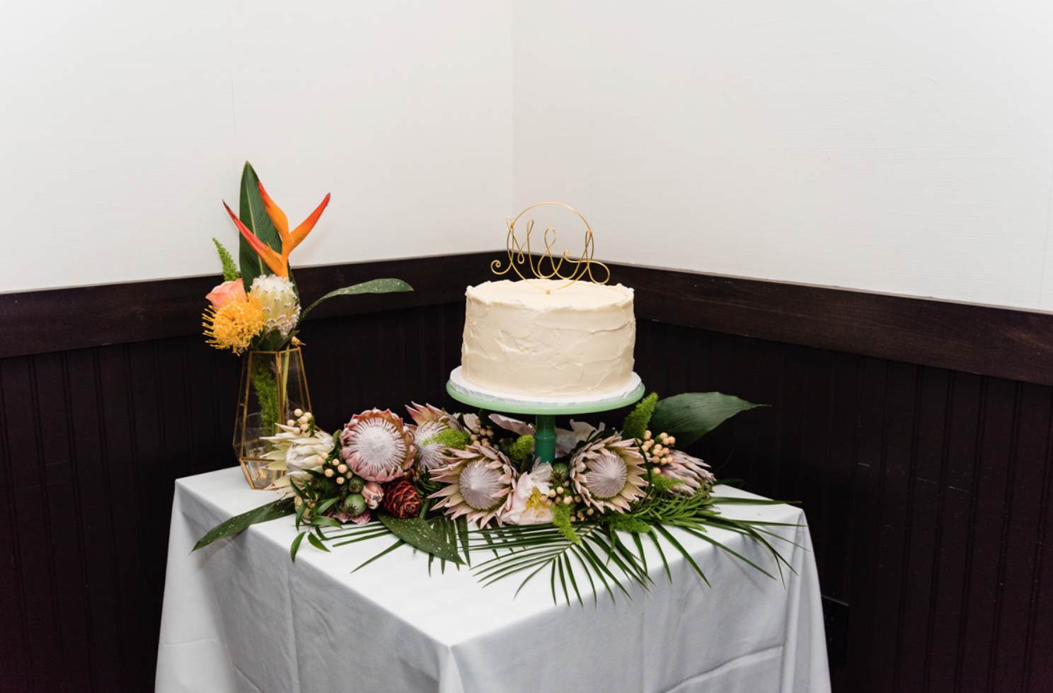 The wedding cake was a white one with a wire topper and served on king proteas