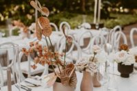 a beautiful and romantic cluster wedding centerpiece with matte vases, blush and rust-colored blooms