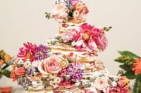 a beautiful waffle wedding cake with strawberries, pink and purple blooms and sugar powder