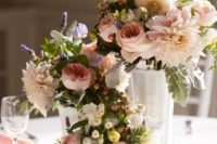 a chic cluster wedding centerpiece of white vases and mugs, with pastel blooms, berries and greenery