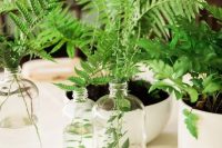 a cluster wedding centerpiece of fern in bottles and vases and potted greenery is a great idea for a modern wedding