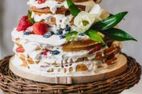 a delicious waffle wedding cake with cream drip, fresh berries, foliage and white blooms is very summer-like