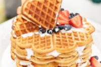 a heart-shaped waffle wedding cake topped with blueberries and strawberries is a tasty and cool dessert