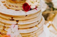a lovely and simple waffle wedding cake with white and red blooms and foliage is a cool idea