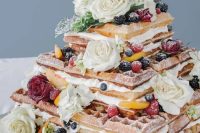 a lovely square waffle wedding cake with creamy, white and red roses and fresh berries is perfect for summer