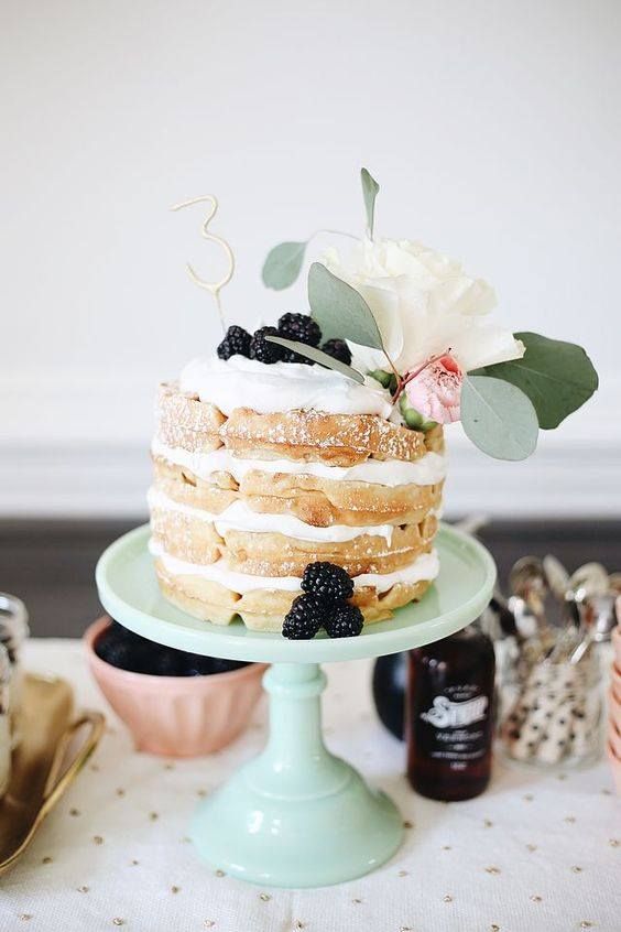 a lovely waffle wedding cake with whipped cream, blackberries and fresh blooms that top it off