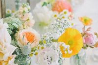 a pastel cluster wedding centerpiece of yellow poppies, blush and white dahlias, peony roses and baby’s breath is chic