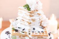 a pretty square waffle wedding cake with cream, fresh berries and neutral blooms on top is amazing