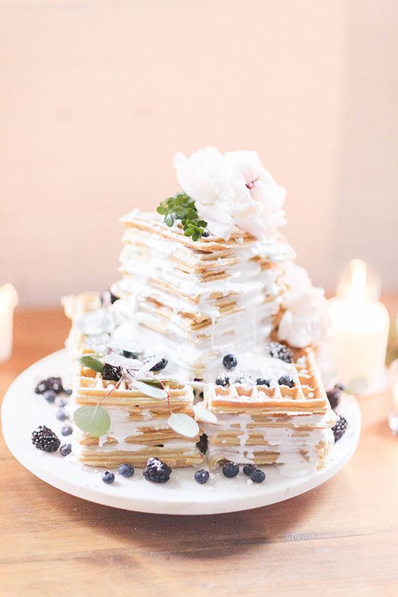a pretty square waffle wedding cake with cream, fresh berries and neutral blooms on top is amazing