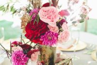 a refined cluster wedding centerpiece of gold vases, pink, fuchsia and burgundy blooms and greenery