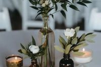 a simple and chic cluster wedding centerpiece of greenery and white blooms plus candles is an easy DIY piece