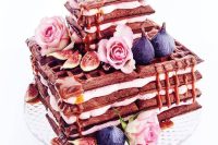 a square chocolate waffle wedding cake with cream, figs, pink roses and some caramel is delicious for the fall