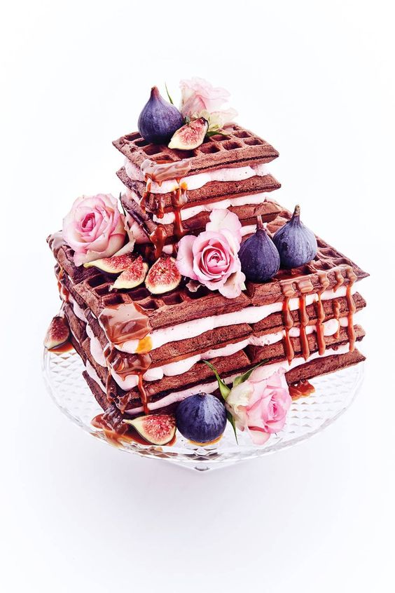 a square chocolate waffle wedding cake with cream, figs, pink roses and some caramel is delicious for the fall