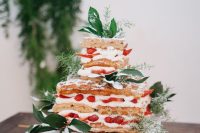 a square waffle wedding cake with cream and strawberries and some greenery is a lovely alternative to a usual cake