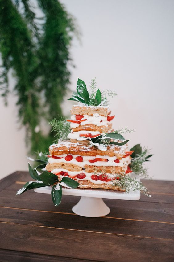 a square waffle wedding cake with cream and strawberries and some greenery is a lovely alternative to a usual cake