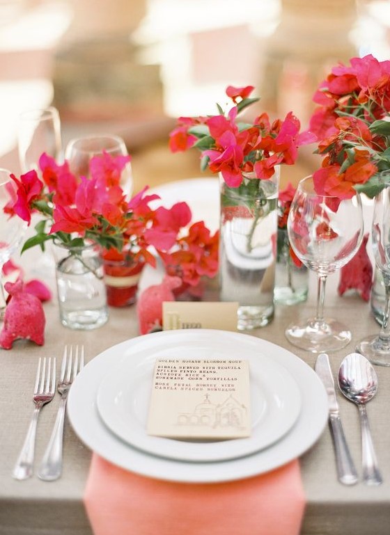 a super bold cluster summer wedding centerpiece of fuchsia blooms in clear vases makes a statement