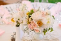 a vintage-inspired cluster wedding centerpiece of white vases, white and blush blooms and pale greenery