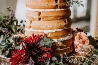 a waffle wedding cake with meringues and pink and burgundy blooms on top for a fall boho wedding